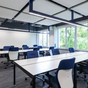 Spacious, modern office interior with blue chairs and ample natural light.