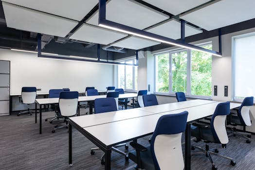 Spacious, modern office interior with blue chairs and ample natural light.